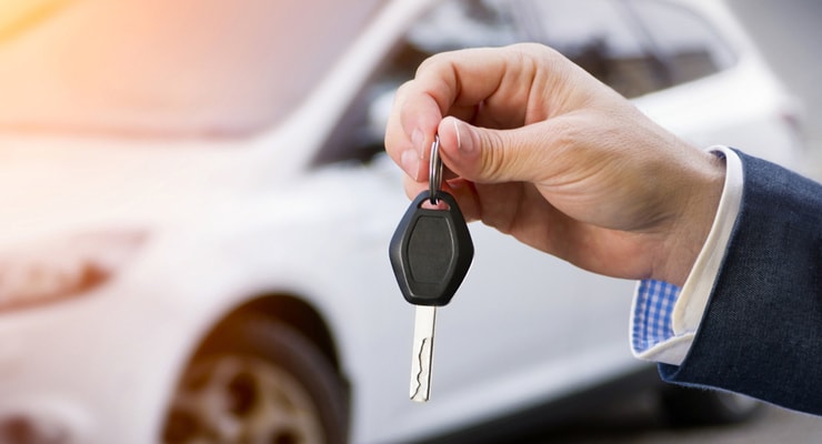 Leasing agent passing keys to excited client, initiating car lease agreement